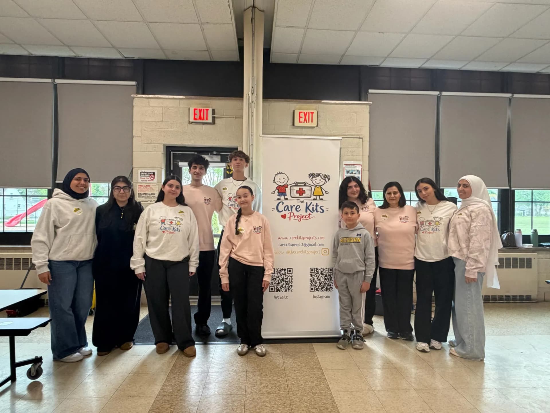 Volunteers gathered around the Care Kits Project banner at Lindbergh Elementary